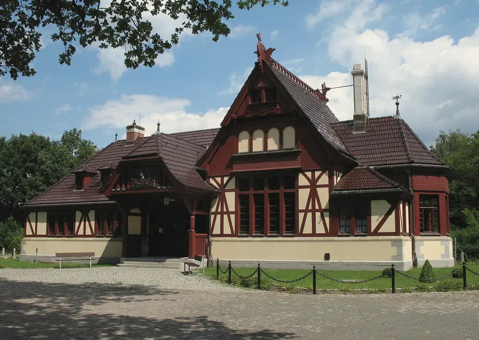 Der Kaiserbahnhof in Joachimsthal: ein Fachwerkbau mit roten Balken und steilem Ziegeldach unter blauem Himmel