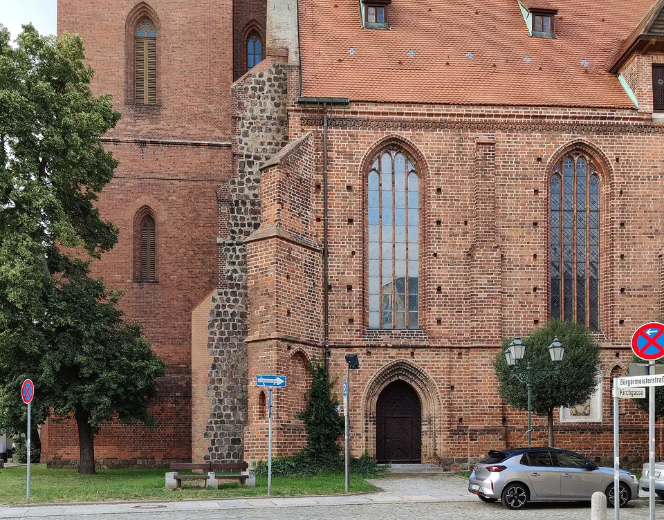 Backsteinfassade der Kirche St. Marien mit Bäumen davor
