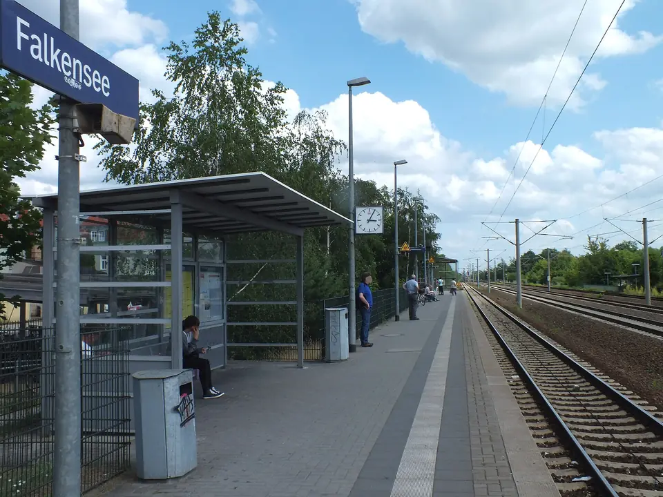 Bahnsteig mit Stationsschild Falkensee und Wartehäuschen