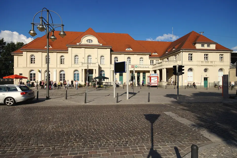 Das Empfangsgebäude des Bahnhofs Oranienburg mit Vorplatz und Laternen an einem sonnigen Tag