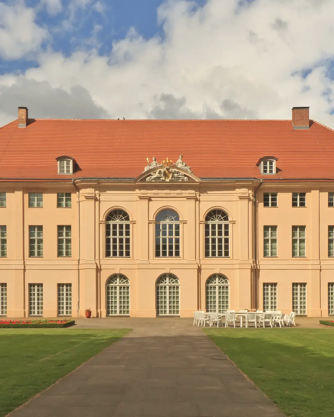 Schloss Schönhausen in Pankow an einem sonnigen Junitag, davor der Rasen und der Weg zum Eingang