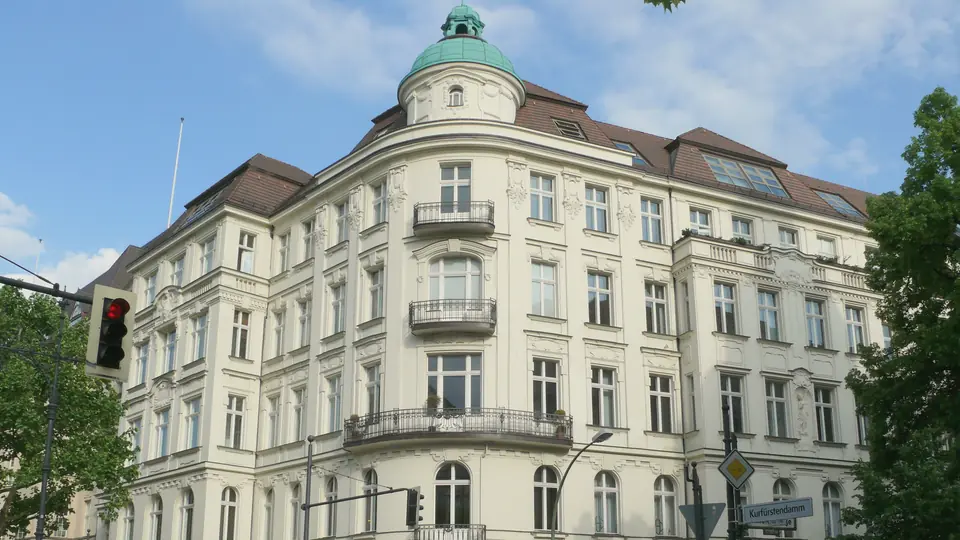 Das Eckhaus Kurfürstendamm 190 in Berlin-Charlottenburg mit grüner Kuppel an einem sonnigen Junitag