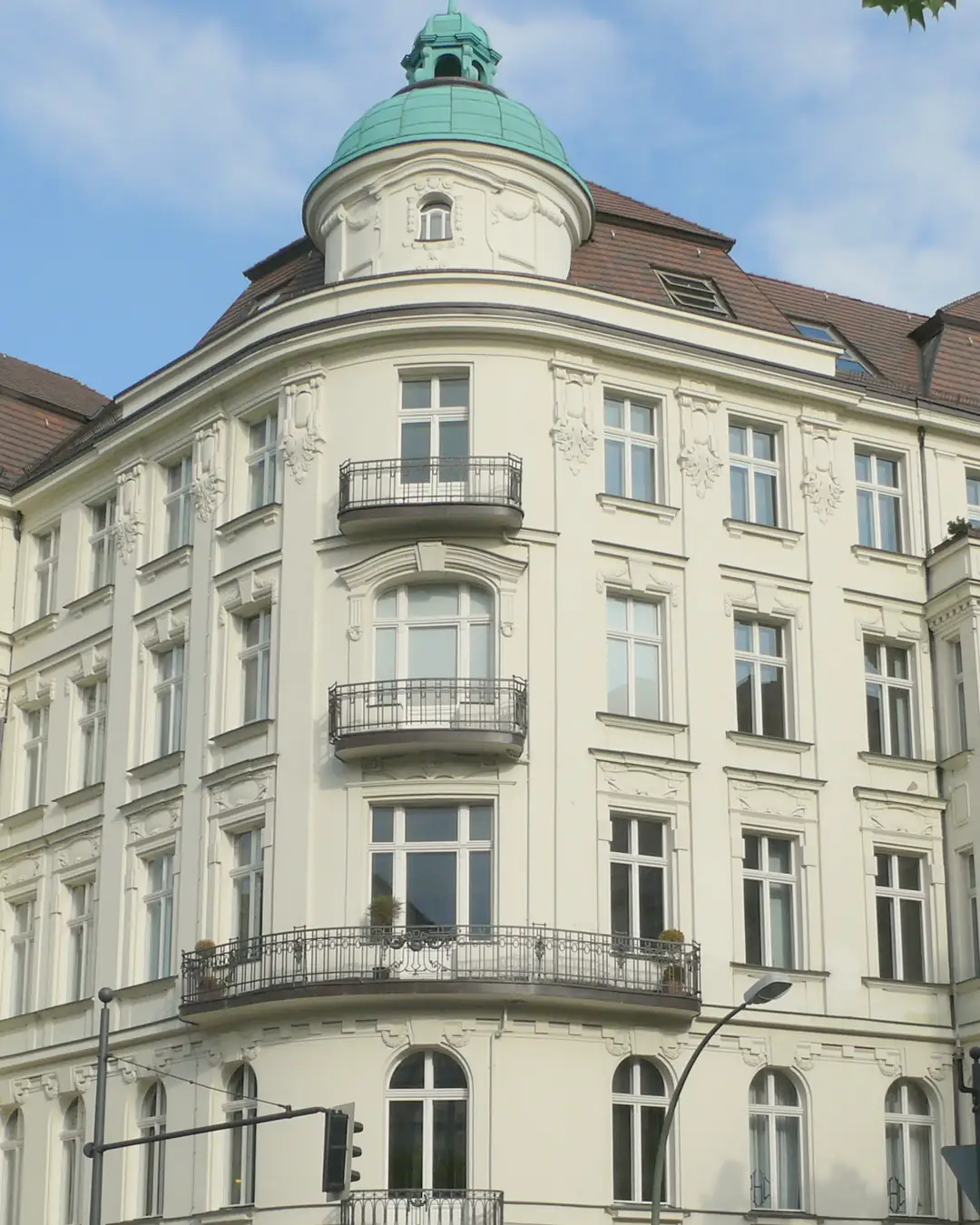 Das Eckhaus Kurfürstendamm 190 in Berlin-Charlottenburg mit grüner Kuppel an einem sonnigen Junitag