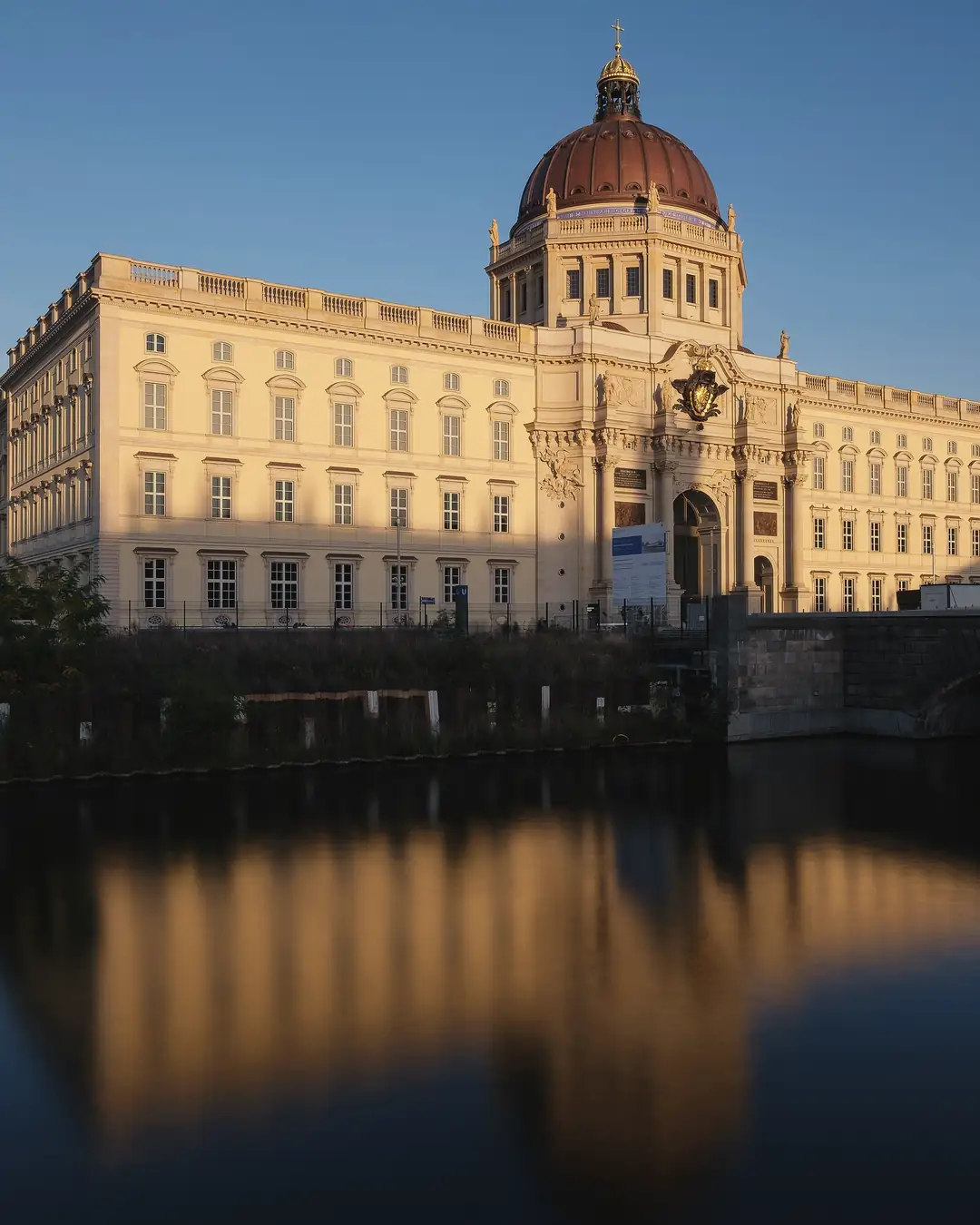 Humboldt Forum mit Kuppel und Fernsehturm in Berlin-Mitte, davor gespiegelt im Wasser